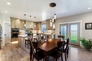Dining space with light wood-style floors and recessed lighting