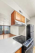 Kitchen with stainless steel appliances and opening to living room