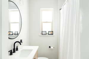 Full bathroom with plenty of natural light, vanity, a shower with shower curtain, and toilet