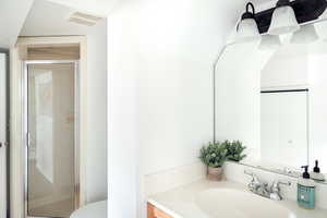 Full bathroom featuring a shower stall, toilet, and vanity