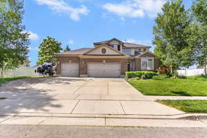 Traditional-style house with an attached garage, concrete driveway, and brick siding