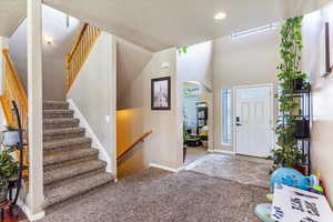 Entryway with arched walkways, stairs, recessed lighting, carpet, and baseboards