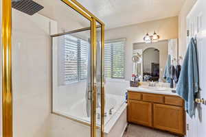 Full bathroom featuring vanity, a bath, and a shower stall
