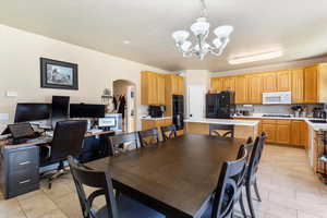 Dining space with arched walkways, a chandelier, light tile patterned floors, and an office area