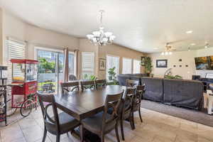 Dining room featuring a textured ceiling, a chandelier, ceiling fan, light tile patterned floors, and recessed lighting