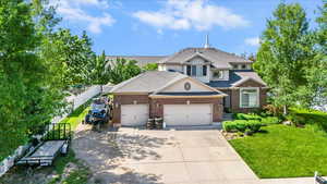 View of front facade with a garage, driveway, brick siding, and roof with shingles