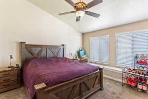 Bedroom with carpet floors, vaulted ceiling, ceiling fan, and baseboards