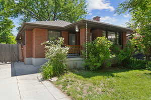View of front of home featuring a chimney and brick siding