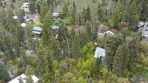 Aerial view of property and surrounding area with a forest