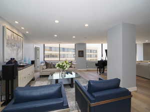 Living area with light wood finished floors, recessed lighting, and baseboards