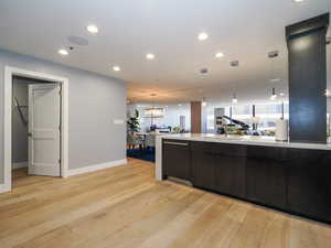Kitchen with light wood-type flooring, light countertops, pendant lighting, baseboards, and recessed lighting