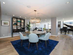 Dining space featuring light wood-type flooring, a chandelier, recessed lighting, baseboards, and healthy amount of natural light