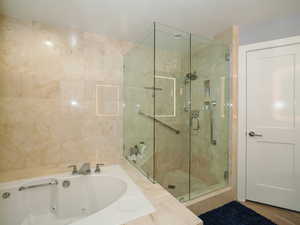 Bathroom featuring a shower stall and a whirlpool tub