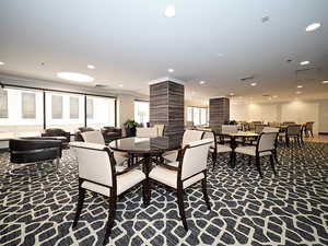 Carpeted dining space with decorative columns and recessed lighting