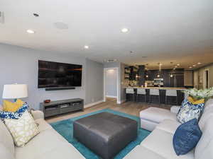Living room with recessed lighting, light wood-style floors, and baseboards