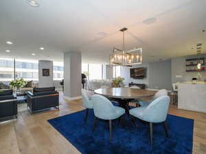 Dining area featuring wood finished floors, a chandelier, baseboards, and recessed lighting