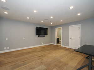 Unfurnished living room featuring baseboards, light wood finished floors, and recessed lighting