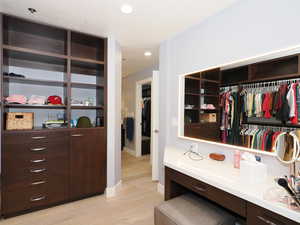 Spacious closet with light wood-type flooring