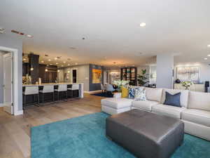Living room featuring light wood-style floors, recessed lighting, baseboards, and a chandelier