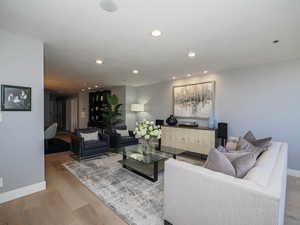 Living area featuring baseboards, wood finished floors, and recessed lighting