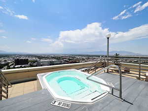 View of pool with a hot tub and a mountain view