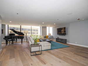 Living room featuring light wood-style flooring, recessed lighting, and baseboards