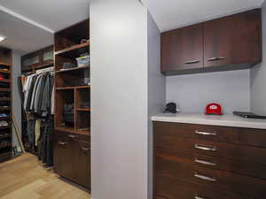 Walk in closet with light wood-style flooring