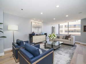 Living area featuring baseboards, recessed lighting, and light wood finished floors