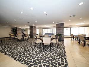 Dining room featuring light tile patterned floors, decorative columns, recessed lighting, and ornamental molding