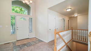 Foyer entrance featuring a chandelier and baseboards