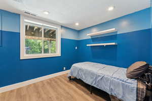 Bedroom with wood finished floors, baseboards, and recessed lighting