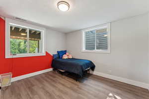 Bedroom featuring wood finished floors and baseboards