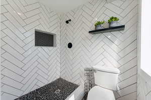 Bathroom with a tile shower and toilet