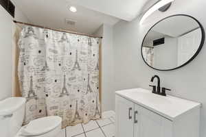 Bathroom with toilet, tile patterned flooring, vanity, a shower with shower curtain, and recessed lighting