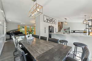 Dining room featuring stairs, a chandelier, and dark wood finished floors