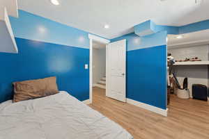 Bedroom featuring wood finished floors, baseboards, and recessed lighting