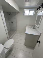 Full bath featuring a stall shower, vanity, toilet, and a textured ceiling