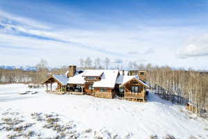 Snow covered house with a chimney and a patio