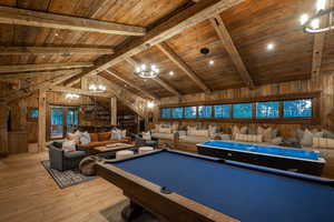 Playroom featuring wood ceiling, wooden walls, wood-type flooring, a chandelier, and pool table
