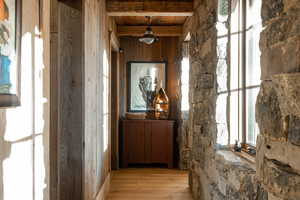 Hall featuring light wood-style floors, beam ceiling, and wooden ceiling