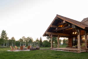 View of green lawn featuring a fire pit and a deck