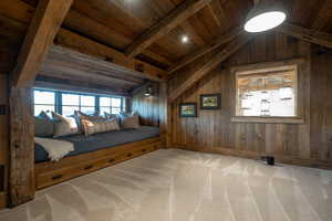 Carpeted bedroom with wooden ceiling and wooden walls