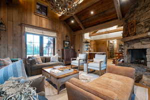 Living room with wood walls, high vaulted ceiling, beam ceiling, a chandelier, and wooden ceiling