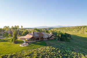 Aerial view of property and surrounding area featuring a mountainous background