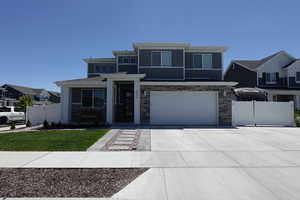Prairie-style home featuring concrete driveway, an attached garage, and stone siding
