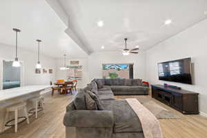 Living room with light wood finished floors, ceiling fan, recessed lighting, a chandelier, and baseboards