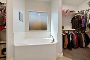 Full bathroom with a garden tub and a walk in closet