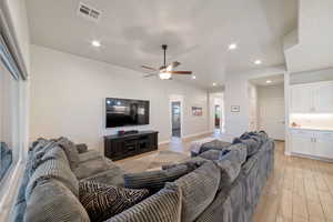 Living room featuring recessed lighting, a ceiling fan, light wood-style floors, and baseboards