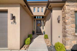 Doorway to property with stucco siding and stone siding