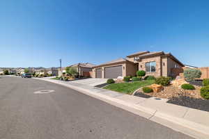 View of front of property featuring stone siding, a garage, stucco siding, a residential view, and driveway